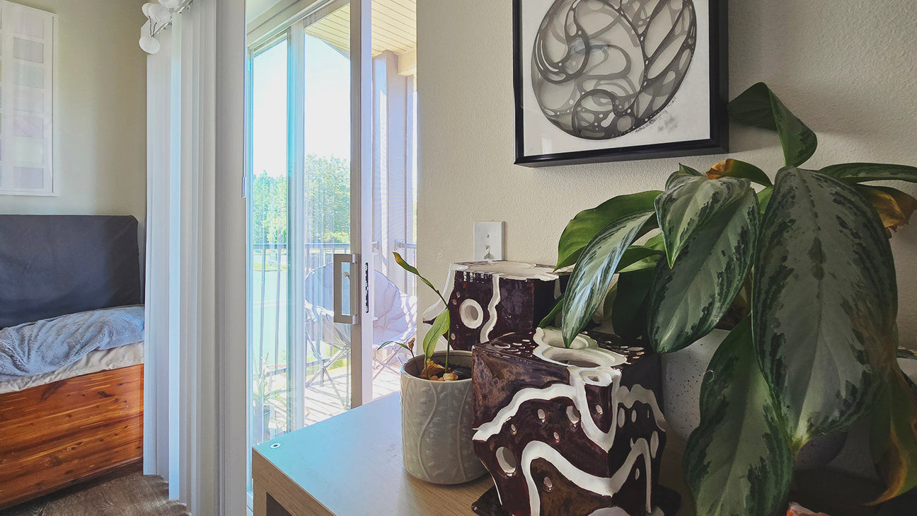 Original abstract sculptures and drawing by Ava Bock displayed in a lived-in home beside houseplants and natural light, illustrating the evolving relationship between art and everyday life.