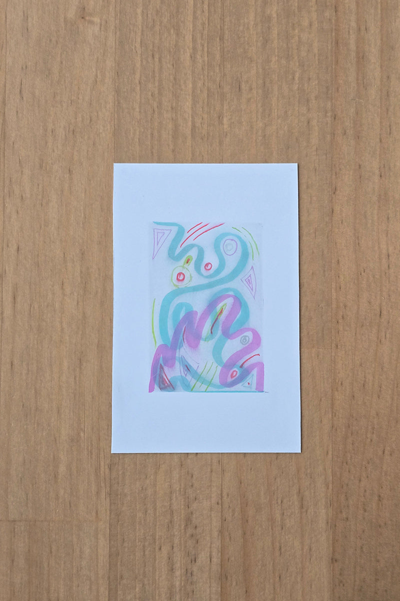 A small abstract artwork on a white rectangular card, featuring pastel swirls of blue, purple, pink, and green on a light wood background.