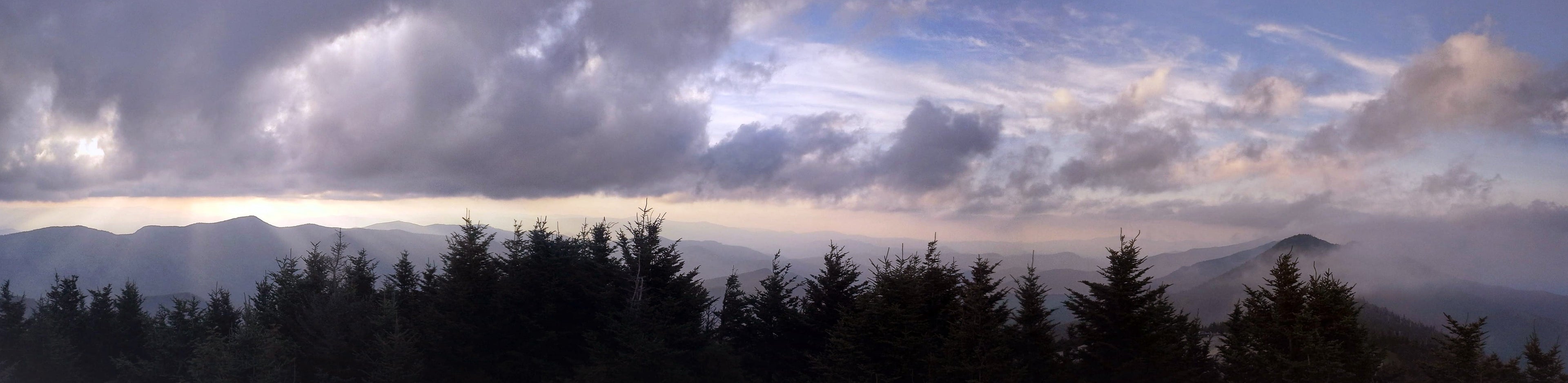 View from Mount Pisgah in the Blue Ridge Mountains of North Carolina, showing layered Appalachian ridgelines beneath dramatic clouds.